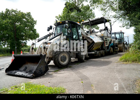 Road Repair Maschinen, Bagger, Walze und Asphalt zur Maschine in einen Feldweg geparkt. Stockfoto