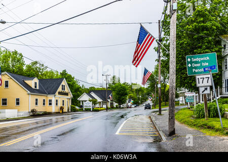 Blue Hill, USA - Juni 9, 2017: Amerikanische Flagge auf Stadt Haupt Straße in Maine während der regnerischen Wetter mit Wegbeschreibung Stockfoto