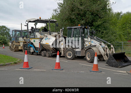 Road Repair Maschinen, Bagger, Walze und Asphalt zur Maschine in einen Feldweg geparkt. Stockfoto