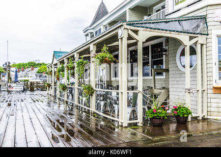 Camden, USA - Juni 9, 2017: Leere waterfront Holz- Restaurant außerhalb Sitzbereich in einem kleinen Dorf in Maine bei Regen durch den Hafen Stockfoto