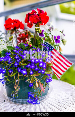 Patriotische Blumentopf mit amerikanischen Fahnen und roten und blauen Blumen auf der Veranda Stockfoto