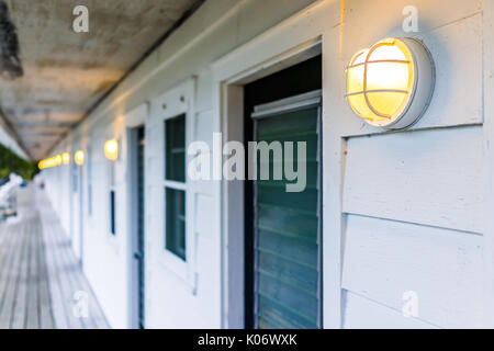 Reihe von Hotel oder Motel Türen außen mit leuchtenden Lampen Lampen in Abend Stockfoto