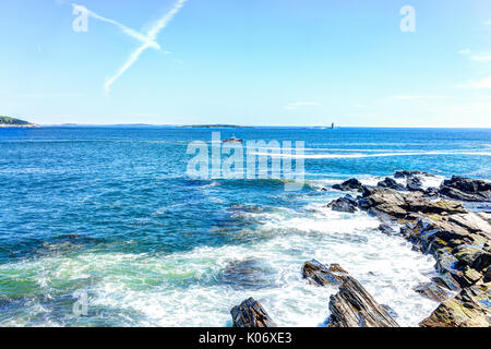 Cliff Felsen mit roten Boot durch Portland Head Lighthouse in Fort Williams Park in Cape Elizabeth, Maine im Sommer Tag Stockfoto