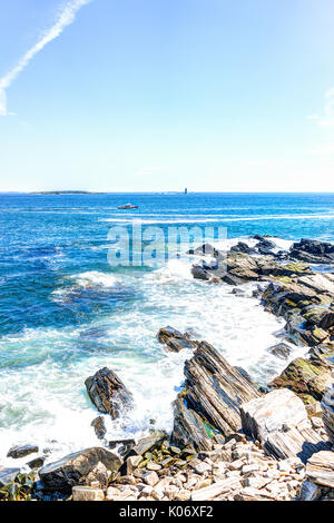 Cliff Felsen mit roten Boot durch Portland Head Lighthouse in Fort Williams Park in Cape Elizabeth, Maine im Sommer Tag Stockfoto