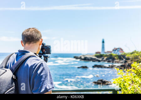 Zurück der Mann Fotograf aufnahmen auf Stativ von Portland Head Lighthouse in Fort Williams Park in Maine im Sommer Tag Stockfoto