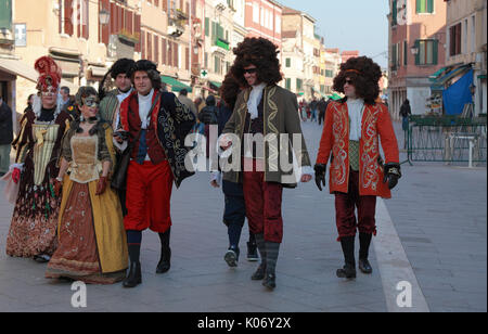 Venedig, Italien - 26. Februar 2011: Gruppe von Menschen glücklich getarnt zu Fuß auf einer Straße in Venedig, während des Karnevals Tage. Der Karneval von Venedig (Carn Stockfoto