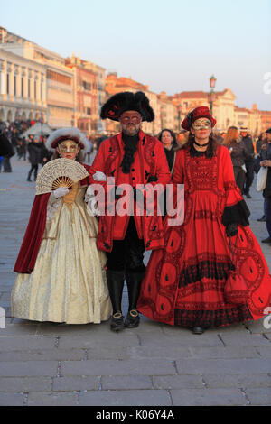 Venedig, Italien - Februar 25th, 2011: Bild in den Sonnenuntergang, der eine Familie tragen traditionelle mittelalterliche Kostüme in Piazza San Marco in Venedig, während des C Stockfoto