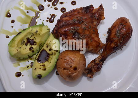 Chicken Drumsticks mit organischen Avocado auf einer weißen Platte Stockfoto