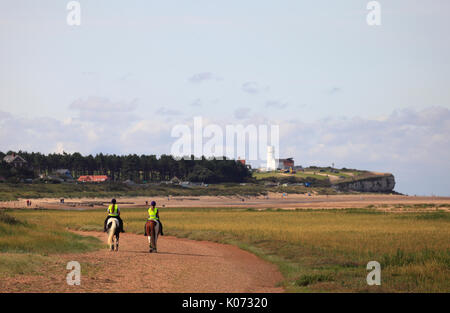 Zwei Fahrer in Richtung Old Hunstanton an der Küste von Norfolk am Strand entlang. Stockfoto