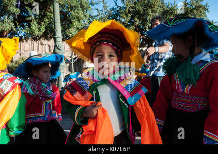 Eine Gruppe von Kindern tragen Quechua Ponchos und montera Hüte Vorbereitung für den Tanzwettbewerb in Corpus Christi Festival, Plaza de Armas, Cusco, Peru Stockfoto