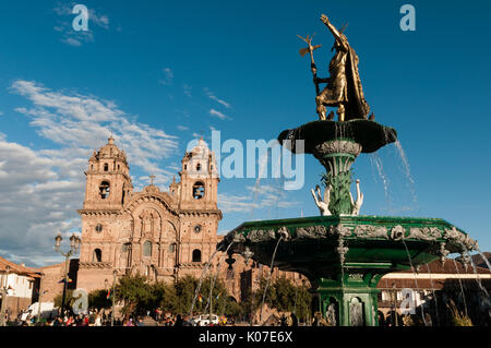 Eine Statue von Pachacuti, ein berühmter Herrscher des Inkareiches, auf dem Plaza de Armas mit der Kirche der Gesellschaft Jesu im Hintergrund, Cusco, Peru. Stockfoto