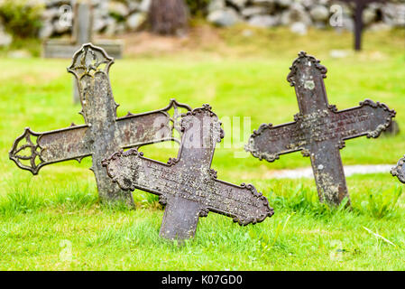 Nore, Norwegen - 14 August 2017: Reisedokumentation der alten Friedhof außerhalb der Stabkirche. Hier drei Metall Kreuze von grünem Rasen umgeben. Stockfoto