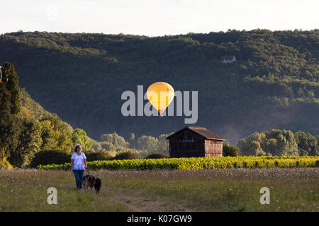 Hot Air Balloon beleuchtet durch die untergehende Sonne, Dordogne, Aquitaine, Frankreich, Europa. Stockfoto