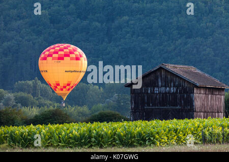 Hot Air Balloon beleuchtet durch die untergehende Sonne Dordogne, Aquitaine, Frankreich, Europa. Stockfoto