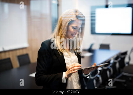 Porträt der schönen blonden Geschäftsfrau holding Tablet Stockfoto