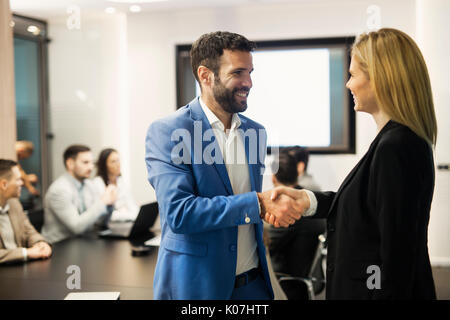 Kaufmann und Kauffrau Händeschütteln in der Sitzung Stockfoto