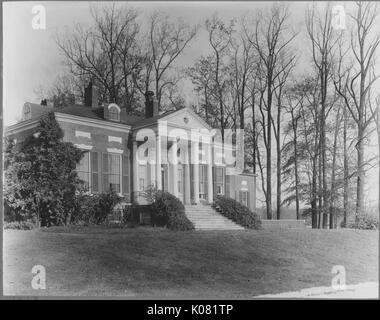 Foto von Homewood Museum auf der Johns Hopkins University Campus, eine kleine 1-stöckige Gebäude mit vier dorischen Säulen vor, große Fenster, auf einem grasbewachsenen Quad entfernt, neben einigen großen Bäumen, die ihr Laub verloren haben, United States, 1950. Dieses Bild wird von einer Reihe dokumentieren den Bau und den Verkauf von Wohnungen in der Roland Park/Guilford Nachbarschaft von Baltimore, einer Straßenbahn Vorort und eines der ersten geplanten Gemeinschaften in den Vereinigten Staaten. Stockfoto