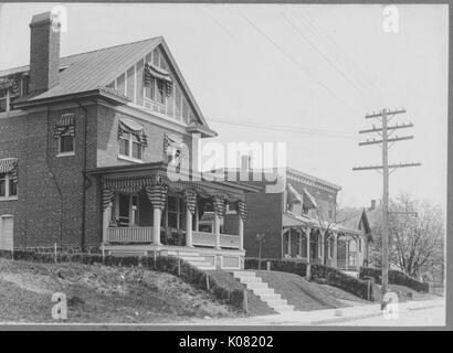 Foto von einer Straße in Baltimore mit Roland Park Homes, oberhalb der Straße gestiegen, sowohl Ziegelsteinhäuser mit großen Veranden zwischen niedrigen Hecken, United States, 1920. Dieses Bild wird von einer Reihe dokumentieren den Bau und den Verkauf von Wohnungen in der Roland Park/Guilford Nachbarschaft von Baltimore, einer Straßenbahn Vorort und eines der ersten geplanten Gemeinschaften in den Vereinigten Staaten. Stockfoto