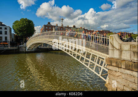 Fußgänger den ikonischen Ha'Penny Bridge über den Fluss Liffey im Zentrum von Dublin, Irland Stockfoto