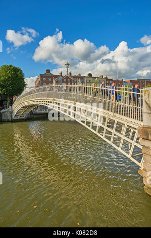 Fußgänger den ikonischen Ha'Penny Bridge über den Fluss Liffey im Zentrum von Dublin, Irland Stockfoto