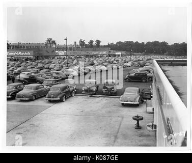 Parkplatz von Northwood Einkaufszentrum, Hunderte von Autos geparkt, Acme-Märkte und liest im Hintergrund, Baltimore, Maryland, 1930. Stockfoto