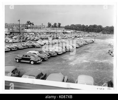 Blick auf einem Parkplatz, im Bau, im Hintergrund ist ein Teil der Northwood Shopping Center und hinter dem Zentrum sind row Häuser links und rechts Bäume, Baltimore, Maryland, 1951. Stockfoto