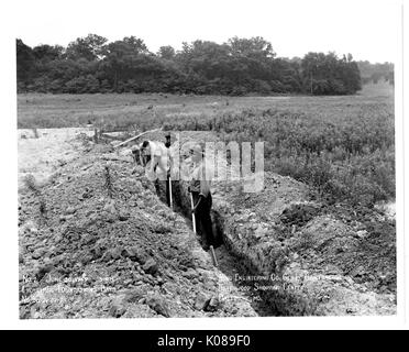 Foto der Arbeitnehmer für Ring Ingenieurbüro Generalunternehmung arbeiten auf dem unbebauten Gelände der Northwood Shopping Center in Baltimore, Maryland, mit Feldern und Bäumen im Hintergrund, Baltimore, Maryland, 30. Juni 1949. Stockfoto