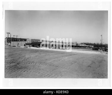 Foto des unbebauten Gelände der Parkplatz für die Northwood Shopping Center in Baltimore, Maryland, mit kommerziellen Gebäuden wie Essen Messe, Wohngebäude, und Bäume im Hintergrund, Baltimore, Maryland, 1950. Stockfoto