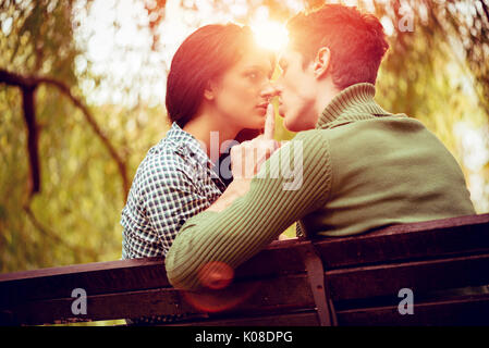 Schöne Paar schöne auf der Bank sitzen und genießen im sonnigen Park in herbstlichen Farben. Stockfoto