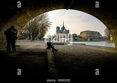 Zwei liebende küssen und Musiker unter der Brücke entlang Seine Fluss, in der Nähe von Notre Dame, Paris, Frankreich. Stockfoto