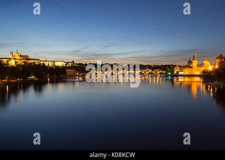 Blick auf den beleuchteten Prag (Hradcany) Schloss, Karlsbrücke, Gebäude in der Altstadt und deren Reflexionen an der Moldau in Prag, bei Nacht. Stockfoto