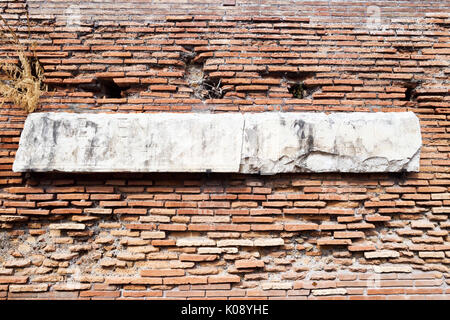 Archäologische Ausgrabungen in Ostia Antica: Römische Mauer mit Marmor mit lateinischen Buchstaben eingraviert. Stockfoto