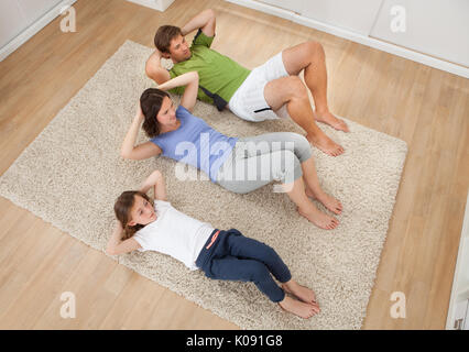 Erhöhte Ansicht der Familie Situps auf Teppich zu Hause zu tun Stockfoto