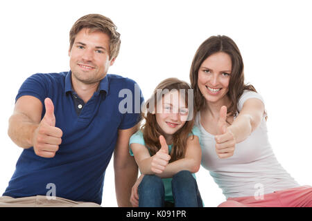 Portrait von Happy Family mit Daumen nach oben zusammen mit weißem Hintergrund Stockfoto