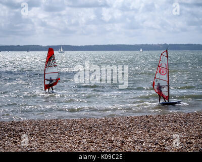 Zwei Windsurfer Segel auf den Solent mit der Isle of Wight im Hintergrund. Stockfoto