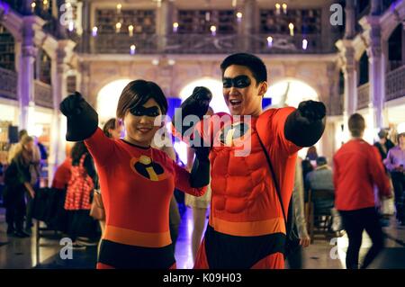 Zwei Studenten, ein Mann und eine Frau in einem Paar, Punkt und Stellen in passenden Kostümen mit Charakteren aus dem Film "The Incredibles", auf Halloween an der Johns Hopkins University's George Peabody Library, 2015. Mit freundlicher Genehmigung von Eric Chen. Stockfoto