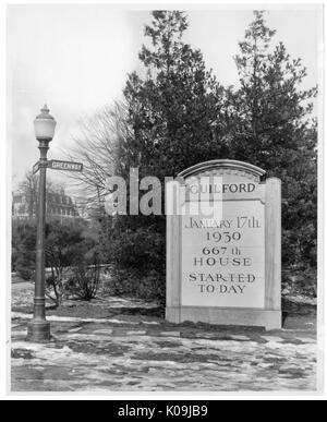 Foto von der Ecke von Greenway Straße in Guilford Nachbarschaft in Baltimore, mit einem großen Stein Schild "17. Januar 1930 667th Haus heute gestartet", mit alten Schnee auf dem Gehweg und große Sträucher und Bäume, Baltimore, Maryland, 1935. Dieses Bild wird von einer Reihe dokumentieren den Bau und den Verkauf von Wohnungen in der Roland Park/Guilford Nachbarschaft von Baltimore, einer Straßenbahn Vorort und eines der ersten geplanten Gemeinschaften in den Vereinigten Staaten. Die Nachbarschaft war getrennt, und gilt als ein frühes Beispiel der Durchsetzung der Rassentrennung durch den Einsatz von eingeschränkt Cov Stockfoto