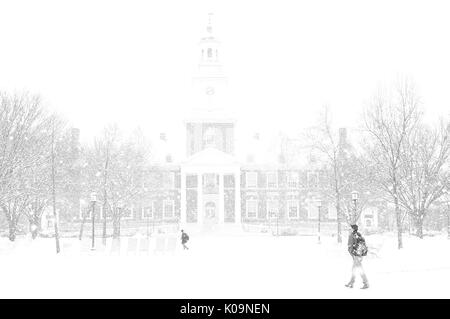 Schnee fällt auf dem Keyser Viereck vor Gilman Hall an der Johns Hopkins University als Studenten Spaziergang zwischen schneebedeckten Bäumen über die Quad auf das Homewood Campus in Baltimore, Maryland, 2015. Mit freundlicher Genehmigung von Eric Chen. Stockfoto