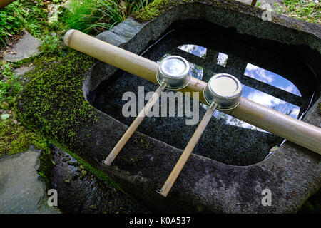 Japanische Kellen bei Shinto Tempel in Kyoto, Japan. In Japan, ein tsukubai ist ein Waschbecken am Eingang zu den heiligen Stätten für die Besucher der t Reinigen bereitgestellt Stockfoto