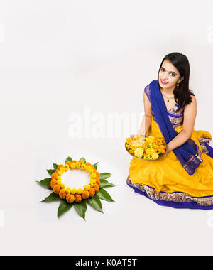 Indische Frau oder junges Mädchen, Blüten oder Blume rangoli für diwali oder onam, auf weißem Hintergrund Stockfoto