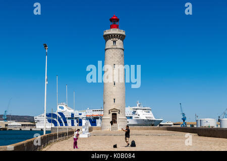 Die Phare du Mole Saint-Louis Leuchtturm in Sete, Frankreich, mit der Gnv majestätisch in den Hintergrund und die Menschen, die Bilder im Vordergrund. Stockfoto