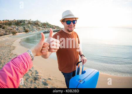 Sommer Urlaub und Ferien - Mann und Frau, Daumen oben am Strand Stockfoto