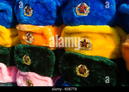 Reihen der russische Winter Mützen in verschiedenen Farben mit Armee Embleme an der Straße Markt an der Arbat-Straße, iconic beliebtes Souvenir aus Russland. Stockfoto