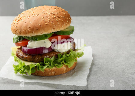Große Burger mit Gemüse und Sauce, Lebensmittel Nahaufnahme Stockfoto