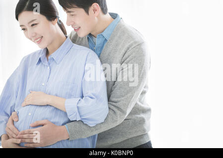 Portrait von Harmonischen schwangeren Paare umarmen Stockfoto
