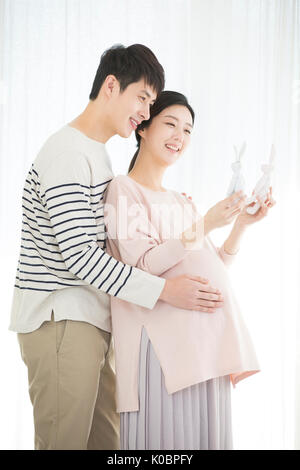 Seitenansicht des Harmonischen schwangeren Paare umarmen Stockfoto
