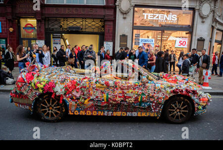 Ein Mann fährt eine aufwendig personalisierten und dekoriert Saab Auto in Oxford Circus, London. Stockfoto