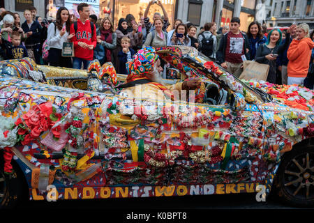 Ein Mann fährt eine aufwendig personalisierten und dekoriert Saab Auto in Oxford Circus, London. Stockfoto