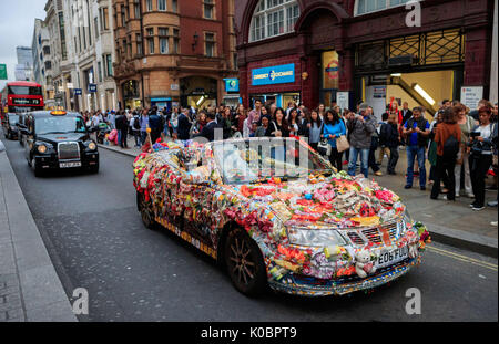 Ein Mann fährt eine aufwendig personalisierten und dekoriert Saab Auto in Oxford Circus, London. Stockfoto