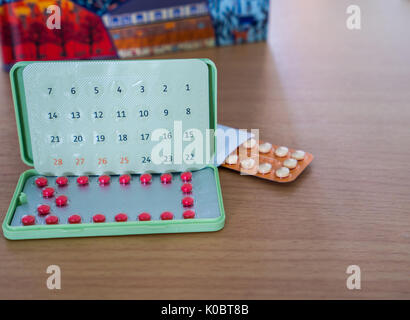 Empfängnisverhütende Pillen mit modernen Paket auf dem Tisch vor Notebook Stockfoto